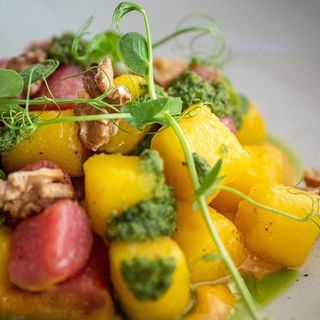 Gnocchi di patate senza farina con panna di carote, pesto di sedano verde, fagiolini e noci tostate